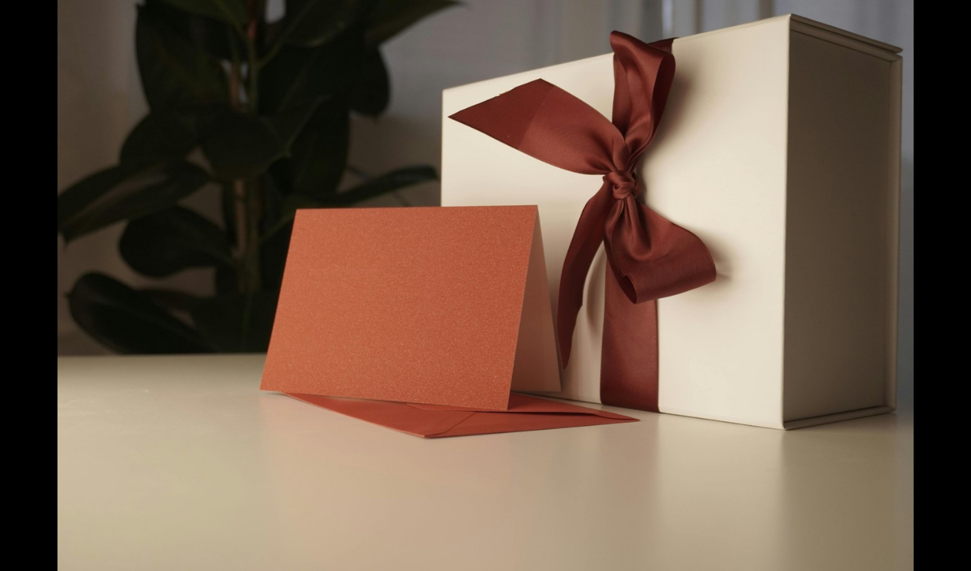 Choosing the Right Gifts for Business Occasions. (IMAGE SOURCE: https://www.pexels.com/photo/white-gift-box-envelope-and-a-greeting-card-lying-on-a-table-19791005/)